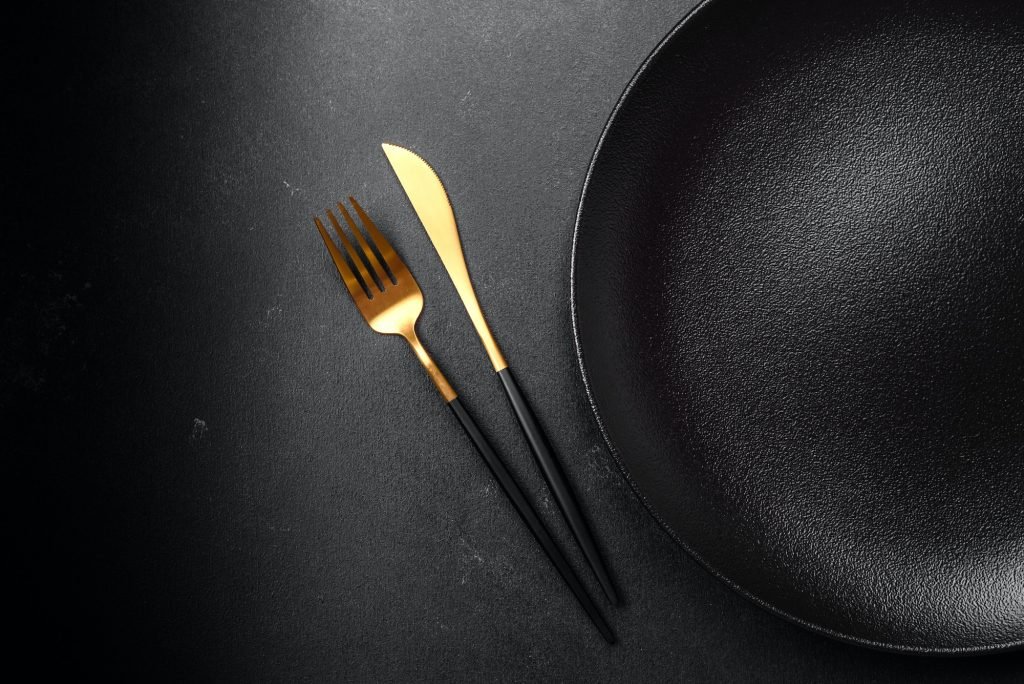 Empty beautiful black ceramic plate on a dark concrete background