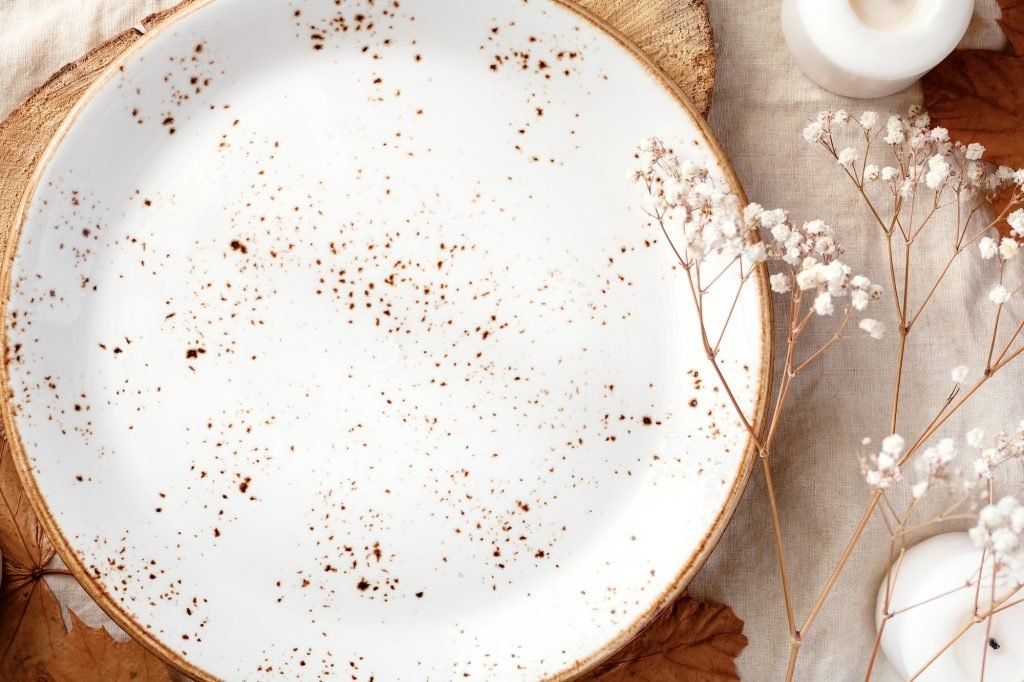 Empty ceramic plate on a wooden tray