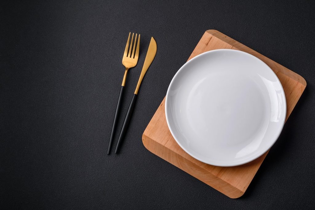 Empty ceramic round plate on dark textured concrete background